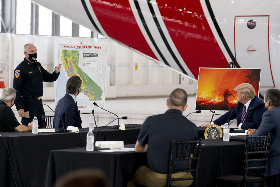 President Donald Trump participates in a briefing on wildfires with Calif. Gov. Gavin Newsom, third from left, at Sacramento McClellan Airport, in McClellan Park, Calif., Monday, Sept. 14, 2020. (AP Photo/Andrew Harnik)