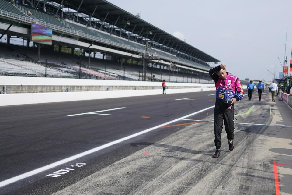 Helio Castroneves, of Brazil, walks down pit lane following a practice session for the IndyCar Indianapolis GP auto race at Indianapolis Motor Speedway, Friday, Aug. 11, 2023, in Indianapolis. (AP Photo/Darron Cummings)