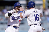 Los Angeles Dodgers' Shohei Ohtani, left, is congratulated by Will Smith after hitting a walk-off single during the 10th inning of a baseball game against the Cincinnati Reds Sunday, May 19, 2024, in Los Angeles. The Dodgers won 3-2. (AP Photo/Mark J. Terrill)