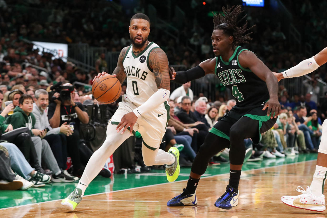 Milwaukee Bucks guard Damian Lillard (0) drives to the basket defended by Boston Celtics guard Jrue Holiday (4) during the second half of Wednesday's game. (Paul Rutherford/USA Today Sports)