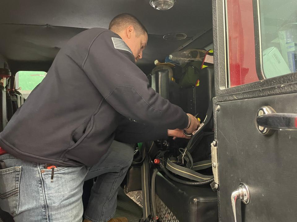 Occum Volunteer Fire Department Chief Scott Eggert inspects a seatbelt on a fire truck.