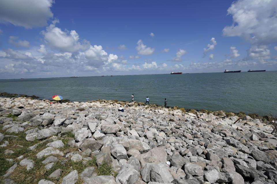 People fish in Galveston Bay on Friday, Sept. 4, 2020, in Galveston, Texas. The Ike Dike is a proposed coastal barrier that would protect the Houston-Galveston region, including Galveston Bay from hurricane storm surge. The project was conceived by Bill Merrell, a professor in the Marine Sciences Department at Texas A&M University at Galveston and a former president of the school, in response to the extensive surge damage caused by Hurricane Ike in September of 2008. (AP Photo/David J. Phillip)