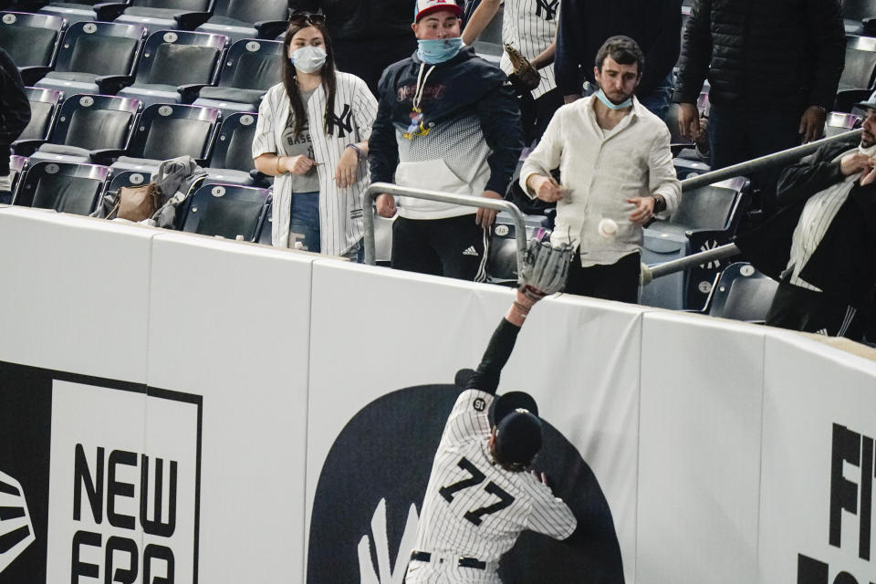 Fans watch as New York Yankees' Clint Frazier leaps for a ball hit by Houston Astros' Yuli Gurriel during the fourth inning of a baseball game Tuesday, May 4, 2021, in New York. (AP Photo/Frank Franklin II)