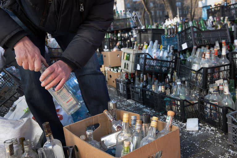 Civiles voluntarios preparan botellas vacías donadas para ser usadas como cócteles Molotov en un centro de recolección ubicado en un estacionamiento de Dnipro, Ucrania, el 27 de febrero de 2022.