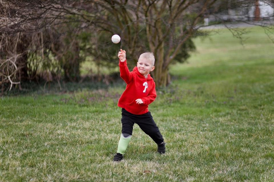 Zeke Clark practices pitching in his Phillies sweatshirt.