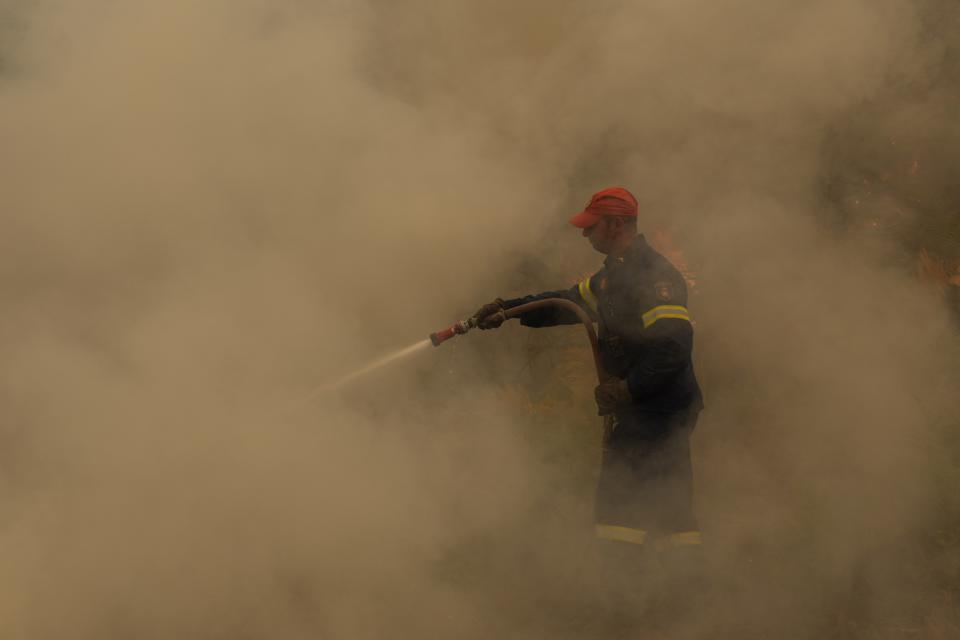 A firefighter operates during a wildfire at Ellinika village on Evia island, about 176 kilometers (110 miles) north of Athens, Greece, Monday, Aug. 9, 2021. Firefighters and residents battled a massive forest fire on Greece's second largest island for a seventh day Monday, fighting to save what they can from flames that have decimated vast tracts of pristine forest, destroyed homes and businesses and sent thousands fleeing. (AP Photo/Petros Karadjias)