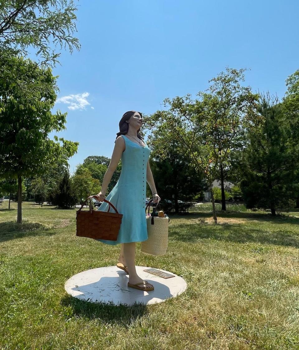 "Wine, Food and Thou" shows the details of preparing for a picnic in a park.  It's on display at Edgewood Road near the Lower Makefield Athletic Complex.
