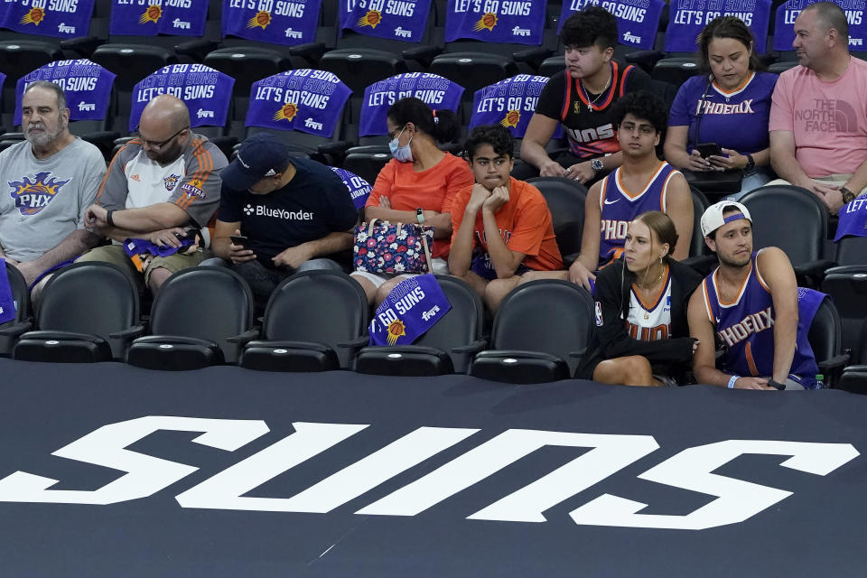 Fans watch players warm up before Game 2 of the NBA basketball Western Conference Finals between the Phoenix Suns and the Los Angeles Clippers, Tuesday, June 22, 2021, in Phoenix. (AP Photo/Matt York)