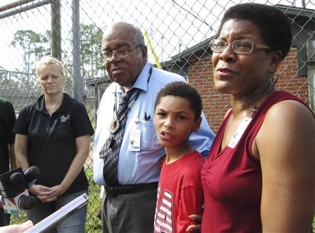 Tananarive Due (R), with her father John Due of Atlanta (2ndL) and her son, Jason Due-Barnes, 9, speaks with reporters outside the gates of the now-closed Arthur Dozier School for Boys in Marianna, Florida, August 31, 2013. REUTERS/Bill Cotterell