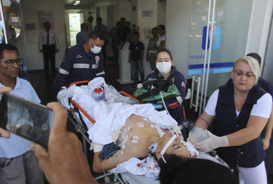 <em>A teenager who was injured during the shooting is carried on a gurney into a hospital (AP)</em>