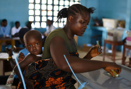 FILE PHOTO: A voter casts her ballot at a polling station during Sierra Leone's general election in Freetown, Sierra Leone March 7, 2018. REUTERS/Olivia Acland/File Photo