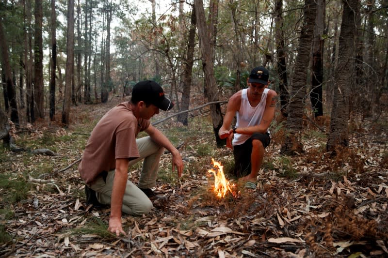 Indigenous Australians Oliver Costello of Firesticks Alliance and Jacob Morris demonstrate cultural burning in a forest in Illaroo
