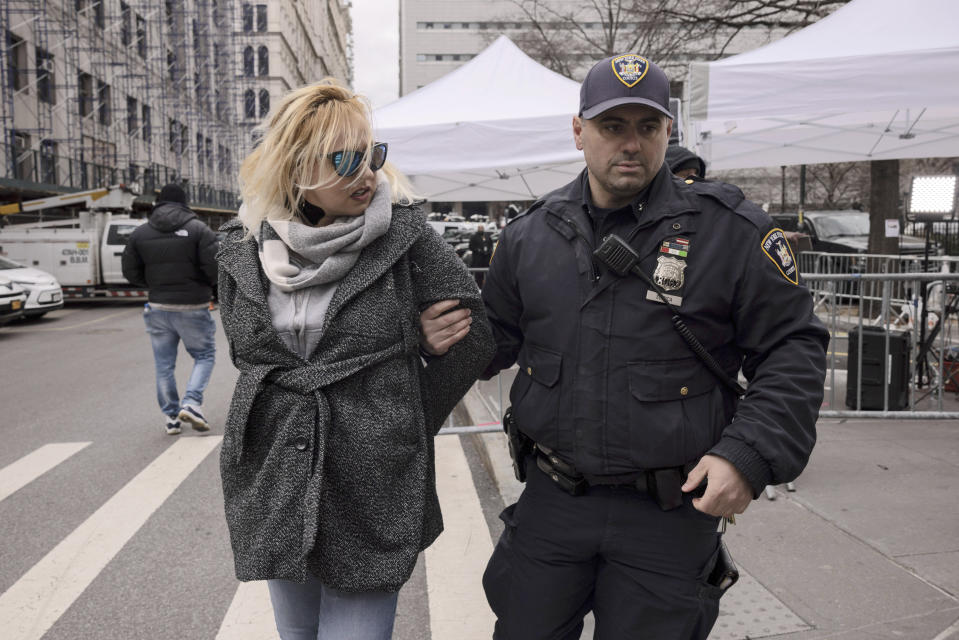 A woman protesting in support of former President Donald Trump is arrested by court officers for getting into an altercation with a pedestrian and brandishing a knife outside the District Attorney's office in New York, Tuesday, March 28, 2023. (AP Photo/Yuki Iwamura)