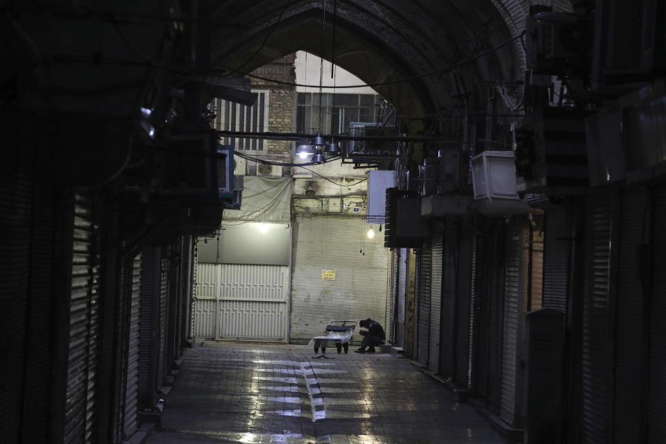 Workers sit at the closed Tehran's Grand Bazaar, Iran's main business and trade hub, Satuday, Nov. 21, 2020. Iran on Saturday shuttered businesses and curtailed travel between its major cities, including the capital of Tehran, as it grapples with the worst outbreak of the coronavirus in the Mideast region. (AP Photo/Vahid Salemi)