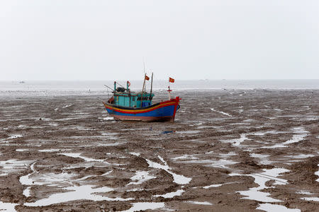 A fishing boat is seen during the low tide at the beach in Thanh Hoa province, Vietnam June 4, 2018. REUTERS/Kham