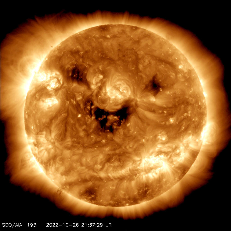 太陽上的這些暗斑被稱為日冕洞（coronal hole），是高速太陽風噴入太空的區塊，形成如同太陽正微笑的可愛模樣。   圖：擷自推特@NASASu