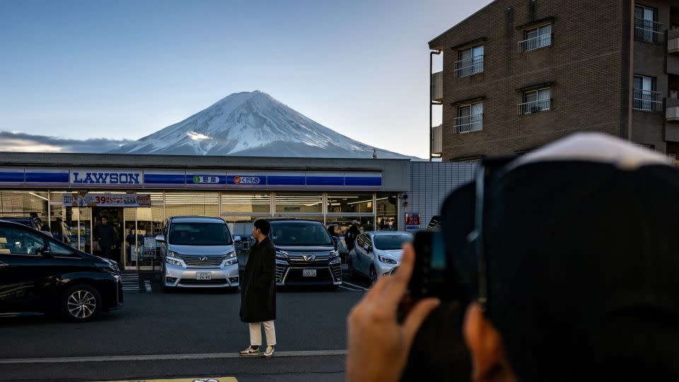 A tourist takes a photo at the site in Fujikawaguchiko where the barrier will be built.  -Philip Fong/AFP/Getty Images