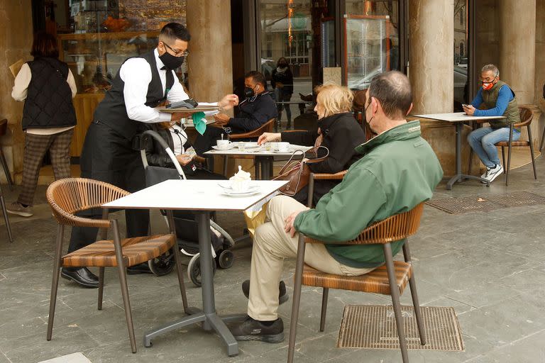 Un camarero atiende a varios clientes en un bar en Palma, Mallorca, Islas Baleares 