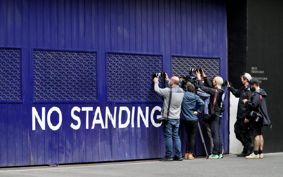 Photographers outside the lawyers' office where Novak Djokovic may have been watching the hearing on Saturday - AP