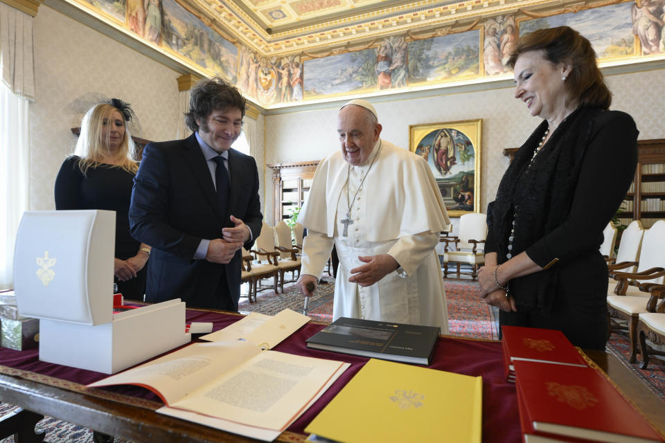 En esta imagen distribuida por la prensa del Vaticano, el presidente argentino Javier Milei, segundo de izquierda a derecha, su hermana y secretaria general de la Presidencia, Karina Milei, izquierda, y la canciller Diana Mondino, derecha, intercambian regalos con el papa Francisco en el estudio del pontífice, el lunes 12 de febrero de 2024, en el Vaticano. (Vatican Media vía AP, HO)