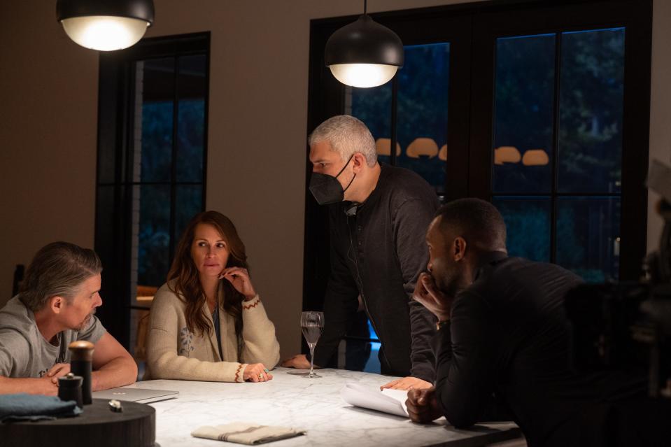 "Leave The World Behind" director Sam Esmail (in mask) talks to actors Ethan Hawke, Julia Roberts and Mahershala Ali. The director made adjustments large and small to the plot of the hit book by the same name before starting filming.