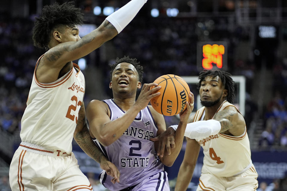 Kansas State guard Tylor Perry (2) is pressured buy Texas forward Dillon Mitchell (23) and guard Tyrese Hunter (4) during the first half of an NCAA college basketball game Wednesday, March 13, 2024, in Kansas City, Mo. (AP Photo/Charlie Riedel)