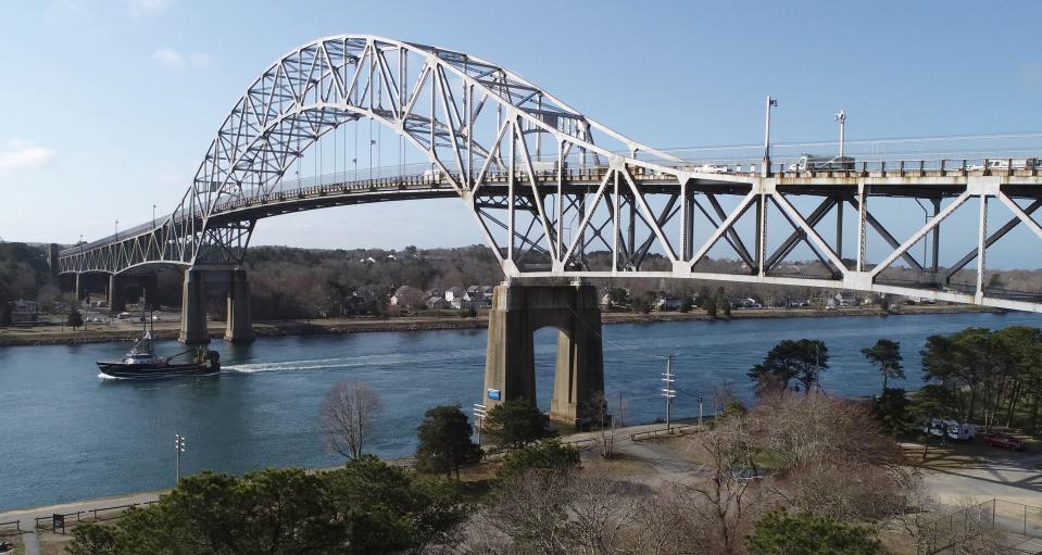 A fishing boat glides through the canal on April 4 as not so lucky motorists over the Bourne Bridge crawl along at a snail's pace due to an overload of vehicles using it to avoid the Sagamore Bridge undergoing construction.