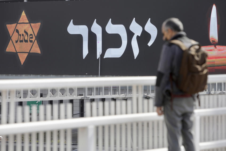 An Israeli stands as sirens mark a nationwide moment of silence in remembrance of the 6 million Jewish victims of the Holocaust, in Tel Aviv, Israel, Thursday, April 8, 2021. (AP Photo/Sebastian Scheiner)