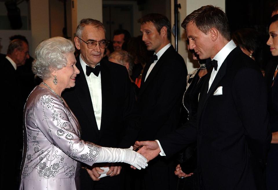 Retour à l'été 2012. Le 27 juillet de cette année, la reine Elizabeth II fait une apparition surprise dans un court-métrage projeté pour la cérémonie d'ouverture des Jeux Olympiques de Londres. Dans celui-ci, la monarque joue aux côtés de Daniel Craig. Sa seule réplique ? <em>"Good evening Mr Bond"</em>, avant que l'agent 007 ne lui propose de l'escorter jusqu'à la cérémonie. Il s'agit-là de l'unique rôle d'actrice de la carrière de la reine Elizabeth. Lors des BAFTA suivants, elle recevra un trophée d'honneur et le président des BAFTA en avait profité pour décrire la reine Elizabeth II comme étant <em>"la James Bond girl la plus mémorable"</em>. (<em>crédit Getty</em>)