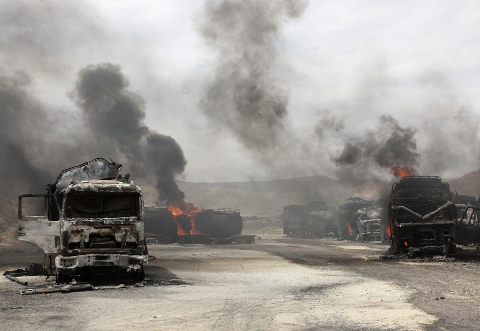 <p>Smoke rises from burning NATO supply trucks in Samangan province, July 18, 2012. A bomb planted by the Taliban destroyed 22 NATO trucks carrying supplies to their forces in northern Afghanistan. (Photo: Stringer/Reuters) </p>