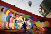 WOOTTON, UNITED KINGDOM - APRIL 07: A hot air balloonist makes preparations for departure from Lydden Hill race circuit near Canterbury to take part in a mass crossing of the Channel on April 7, 2011 in Wootton, England. 51 balloonists of various nationalities from across Europe took off from Kent making for Calais, France at about 7am. It is the first time a Guinness World Record bid has been made for "the largest group of hot air balloons to make the Channel crossing". (Photo by Oli Scarff/Getty Images)