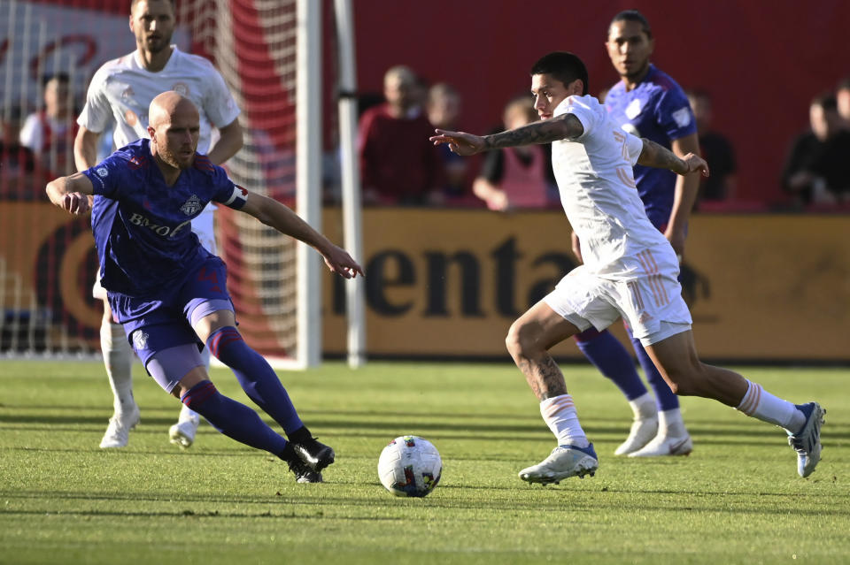 Toronto FC's Michael Bradley, left, and Chicago Fire's Federico Navarro chase the ball during the first half of an MLS soccer match Saturday, May 28, 2022, in Toronto. (Jon Blacker/The Canadian Press via AP)