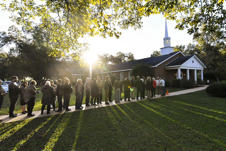 In this Nov. 3, 2019, photo, the sun breaks the horizon as guests begin lining up to attend Sunday school class taught by former President Jimmy Carter at the Maranatha Baptist Church, in Plains, Ga. (AP Photo/John Amis)