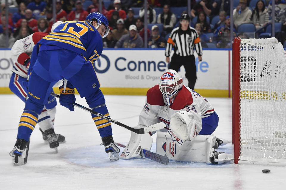 Buffalo Sabres center Tage Thompson, left, puts a shot between his legs and wide of the gaol as Montreal Canadiens goalie Jake Allen looks on during the second period of an NHL hockey game in Buffalo, N.Y., Monday, Oct. 23, 2023. (AP Photo/Adrian Kraus)