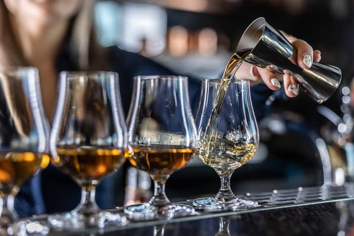 a bartender pouring drinks in glasses