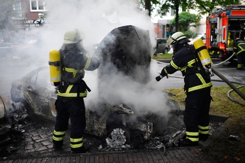 Fire crews extinguish a burning car in the street during the 'Welcome to Hell' anti-G20 protest march. (Alexander Koerner/Getty Images)