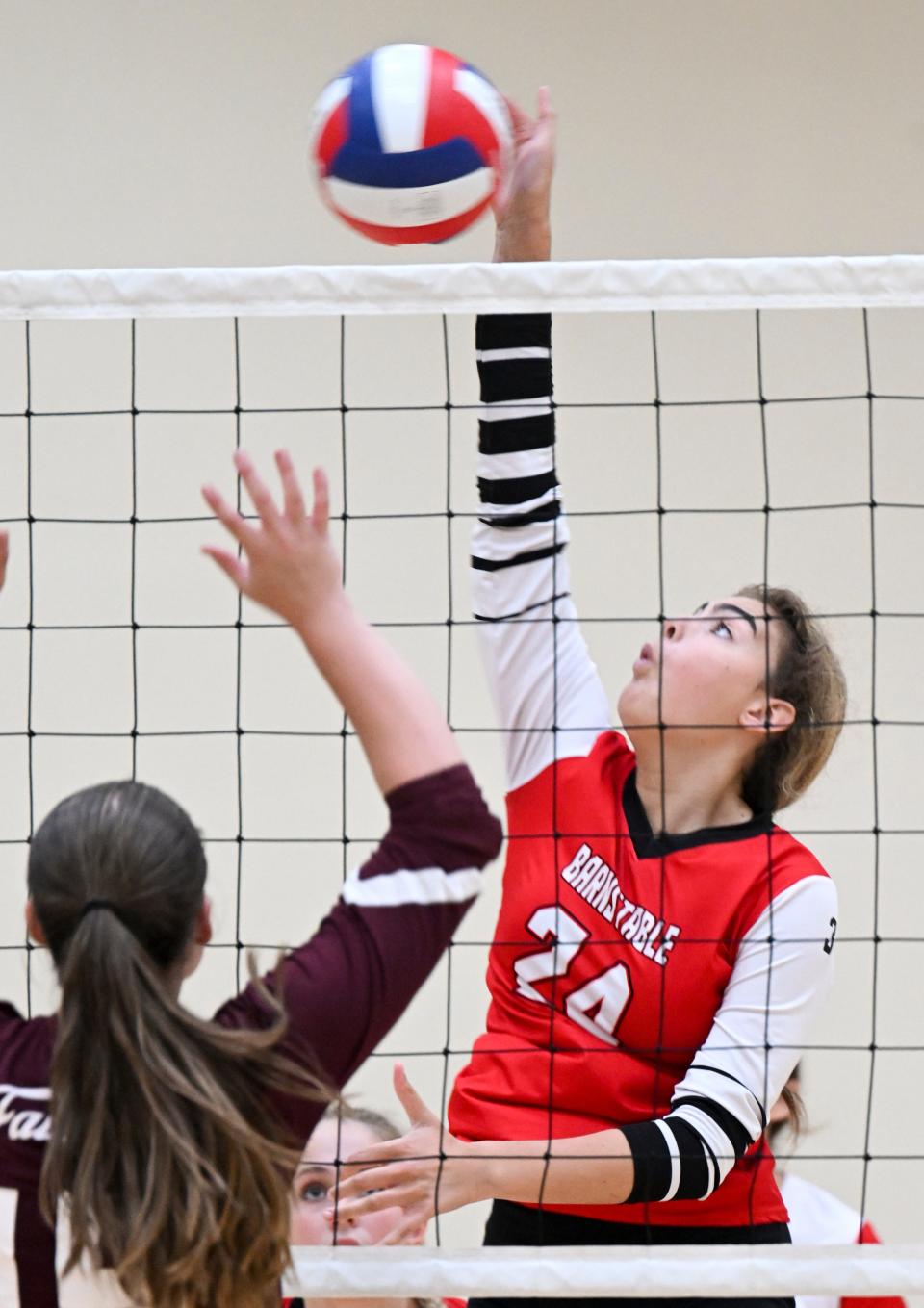 Charlotte Sullivan of Barnstable spikes the ball against Aurora Kinworthy of Falmouth in September of 2022.