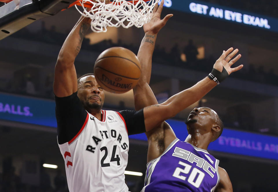 Toronto Raptors guard Norman Powell, left, stuffs against Sacramento Kings forward Harry Giles III, right, during the first quarter of an NBA basketball game in Sacramento, Calif., Sunday, March 8, 2020. (AP Photo/Rich Pedroncelli)