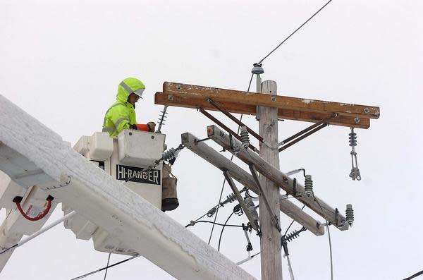 A National Grid worker works on a utility pole.