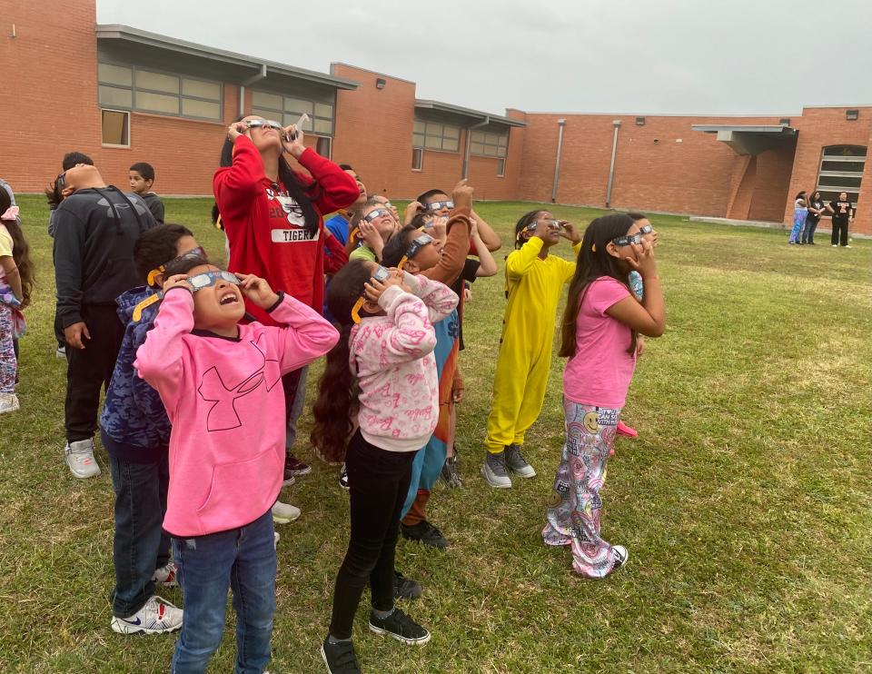 Oak Park Elementary School teacher Stacy Flores's second grade class attempts to catch a glimpse of a solar eclipse on a cloudy day on Monday.