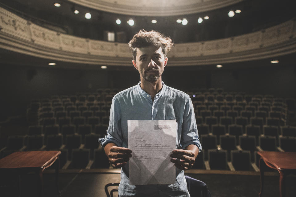 Mihail Zui, 39, an actor of the Yanka Kupala National Theater poses for a photo showing his resignation letter in Minsk, Belarus, Tuesday, Aug. 18, 2020. After the theater's influential and popular director decided to support the protesters, he was fired — and Zui and most of the other performers quit in solidarity and anger. (AP Photo/Evgeniy Maloletka)