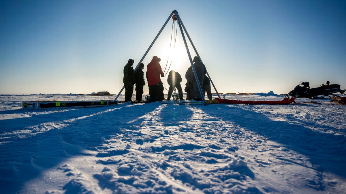 Scientists from Nasa’s Jet Propulsion Laboratory test a prototype ‘IceNode’ robot in the Beaufort Sea in March.  The agency’s project sends the robots under ice to collect data for a year. (Credit: U.S. Navy/Scott Barnes)