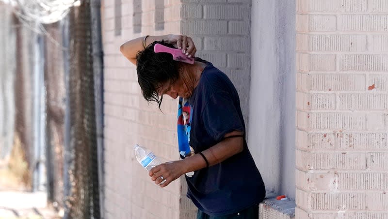 A person tries to cool off in the shade, Tuesday, July 18, 2023, in Phoenix. Extreme temperature fluctuations linked to climate change could be a factor in roughly a half-million deaths and additional cases of disability from stroke around the world, according to a new study published in Neurology,