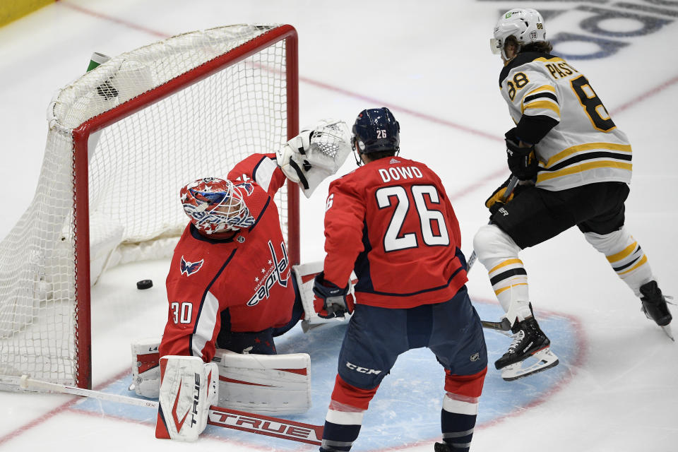 Boston Bruins right wing David Pastrnak (88) scores a goal past Washington Capitals goaltender Ilya Samsonov (30) and center Nic Dowd (26) during the second period in Game 5 of an NHL hockey Stanley Cup first-round playoff series, Sunday, May 23, 2021, in Washington. (AP Photo/Nick Wass)