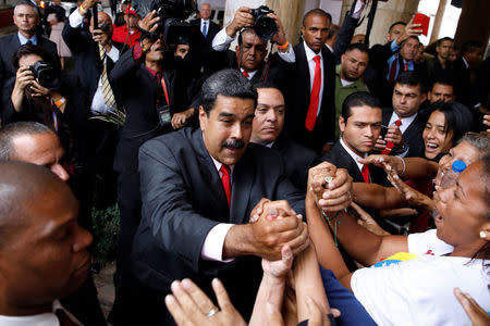 Venezuela's re-elected President Nicolas Maduro greets his supporters as he leaves after receiving a certificate confirming him as winner of Sunday's election at the National Electoral Council (CNE) in Caracas, Venezuela May 22, 2018. REUTERS/Carlos Garcia Rawlins