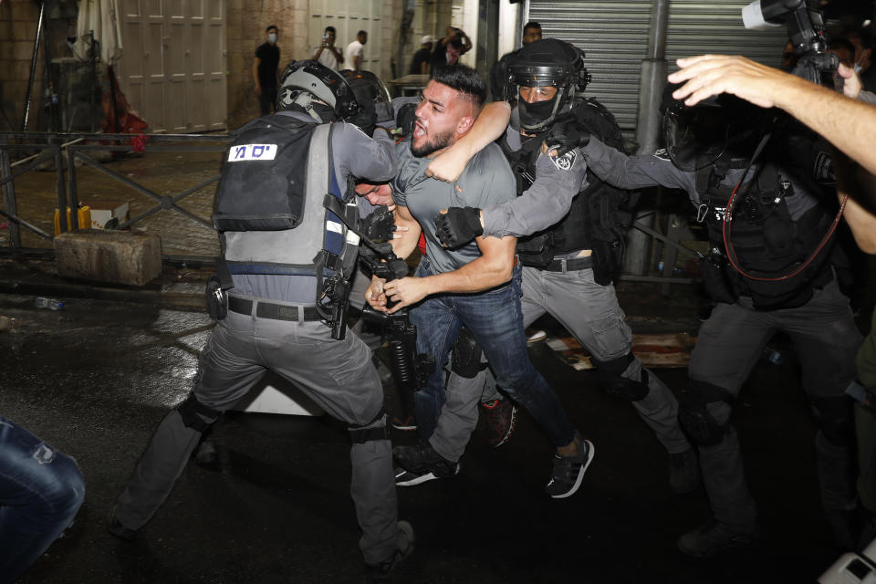 Agentes de la policía israelí chocan con manifestantes palestinos cerca de la Puerta de Damasco, en la Ciudad Vieja de Jerusalén, el domingo 9 de mayo de 2021. (AP Foto/Ariel Schalit)