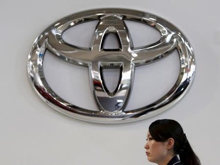 A woman walks under a logo of Toyota Motor Corp at the company's showroom in Tokyo, Japan, August 4, 2015. REUTERS/Yuya Shino