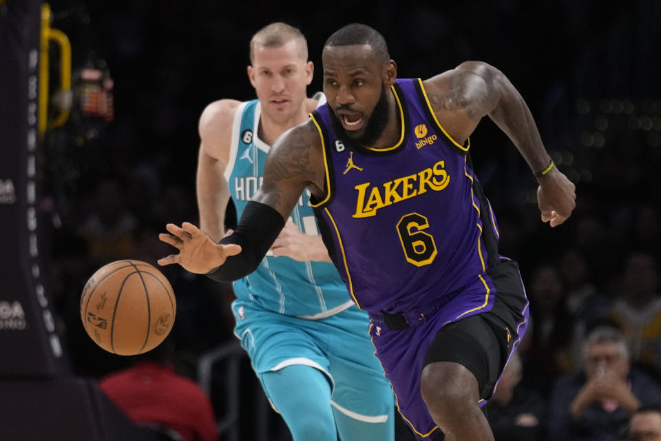 Los Angeles Lakers forward LeBron James (6) dribbles past Charlotte Hornets center Mason Plumlee during the first half of an NBA basketball game Friday, Dec. 23, 2022, in Los Angeles. (AP Photo/Marcio Jose Sanchez)