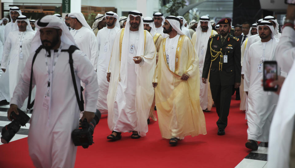 Abu Dhabi's powerful crown prince, Sheikh Mohammed bin Zayed Al Nahyan, left, speaks to Dubai's ruler, Sheikh Mohammed bin Rashid Al Maktoum, right, at the International Defense Exhibition and Conference in Abu Dhabi, United Arab Emirates, Sunday, Feb. 17, 2019. The biennial arms show in Abu Dhabi comes as the United Arab Emirates faces increasing criticism for its role in the yearlong war in Yemen. (AP Photo/Jon Gambrell)