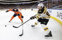 Boston Bruins left wing Brad Marchand (63) gets then pass away as Edmonton Oilers' Alex Chiasson (39) defends during the first period of an NHL hockey game, Wednesday, Feb. 19, 2020 in Edmonton, Alberta. (Jason Franson/The Canadian Press via AP)